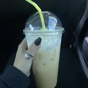 a hand holding a cup of iced coffee