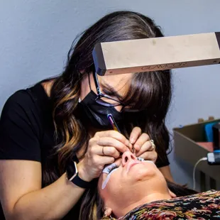 Woman getting eyelash extensions.