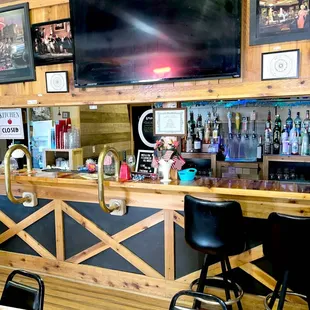 a bar with a television and bar stools