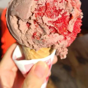 a hand holding a cone of ice cream