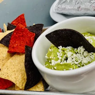 a bowl of guacamole and tortillas