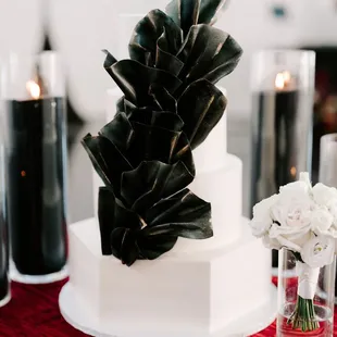 a white wedding cake with black flowers