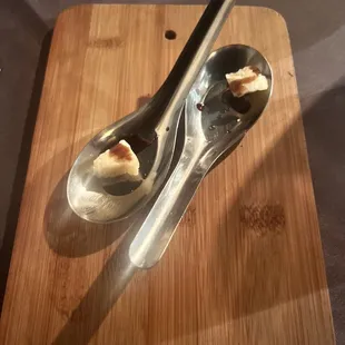 a spoon and a spoon with a piece of bread on it
