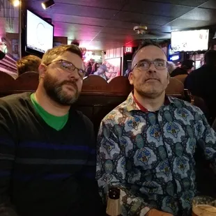 two men sitting at a bar