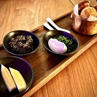 three bowls of food on a wooden tray