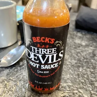 a bottle of three devils hot sauce