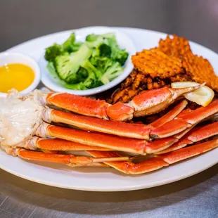 a plate of crab legs, rice and broccoli