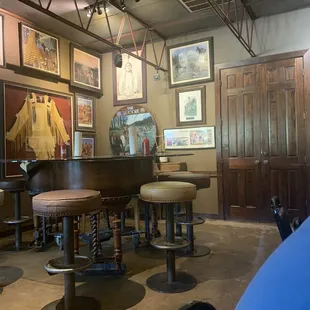 ows a bar with stools and a piano