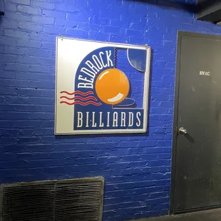 a blue brick wall with a sign on it