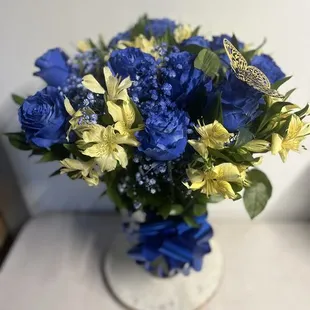 Un hermoso arreglo de flores azules y amarillas un hermoso detalle para cualquier ocasión