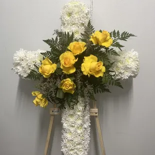 Una cruz de funeral de flores blancas y amarillas un hermoso detalle para despedir a un ser querido