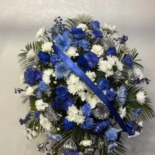 Un arreglo de funeral de flores azules blancas y plateadas un hermoso detalle para despedir a un ser querido