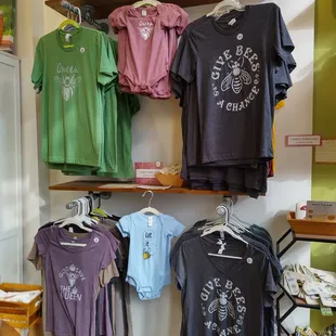 a variety of t - shirts hanging on a wall