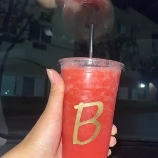 a person holding a drink in their hand