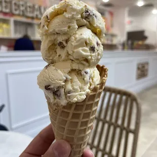 a hand holding a cone of ice cream