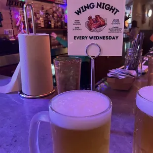 two mugs of beer on a bar