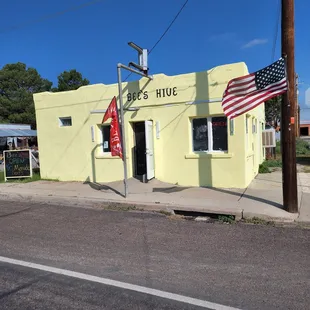a yellow building with an american flag