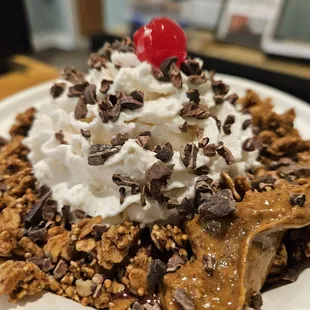 a banana split topped with whipped cream and chocolate chips