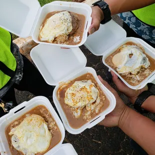 a group of people holding containers of food