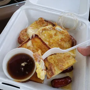 a hand holding a fork and a container of food