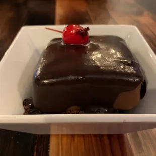 a piece of chocolate cake with a cherry on top