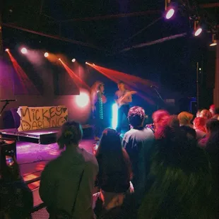 a crowd of people standing in front of a stage