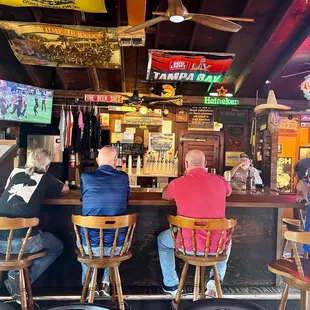 three men sitting at a bar