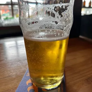 a glass of beer on a coaster