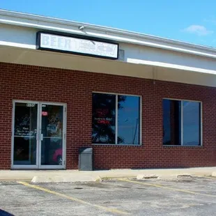 a red car parked in front of a brick building