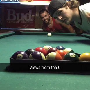 a man leaning over a pool table