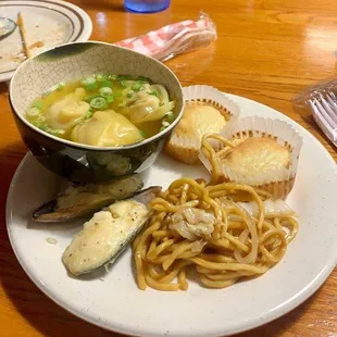 a bowl of soup, pasta, and bread