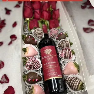 a bottle of wine and chocolate covered strawberries