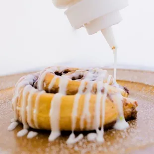 a pastry being drizzled with icing