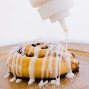 a pastry being drizzled with icing