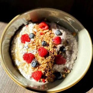 a bowl of oatmeal with berries and granola