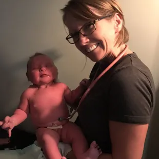 Midwife Amy, from Beginnings Birth Center, holding our freshly delivered baby at our beautiful home birth!