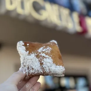 a hand holding a doughnut