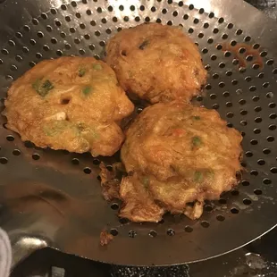 three fried food items in a strainer