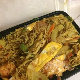 a tray of noodles with shrimp and vegetables