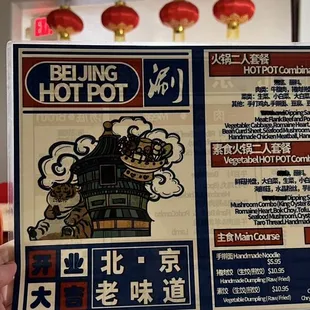 a person holding up a menu