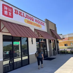 a woman walking in front of a chinese restaurant