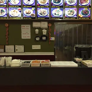 a restaurant counter with a lot of menus