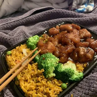 a plate of chinese food with chopsticks