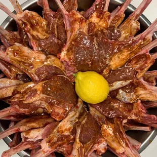 a plate of lamb chops with a lemon