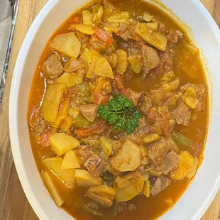 a bowl of stew on a cutting board