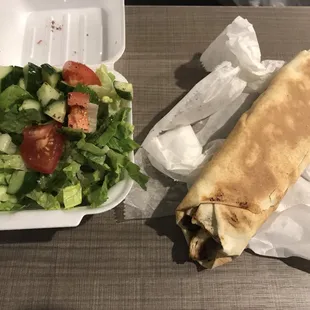 a salad and a burrito on a table