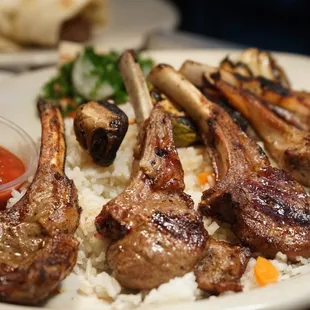 a plate of lamb chops and rice
