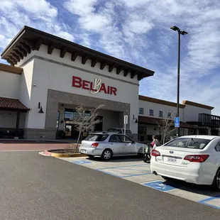two cars parked in front of a bel air store