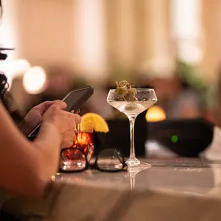 a woman sitting at a bar using her cell phone