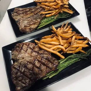 two plates of steak and french fries